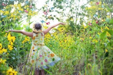 Gardening for better health and wellbeing. Happy girl in a flower meadow. Gardening For Better Health And Wellbeing